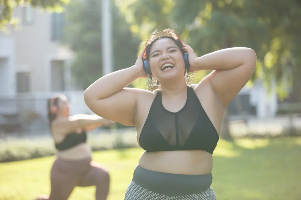 Woman listening to music and dancing in a park