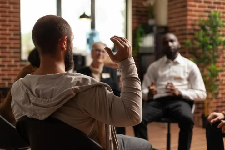 Man with addiction sharing mental health issues with group at aa meeting