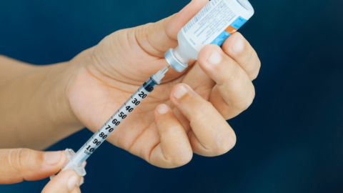 Person preparing insulin for injection|