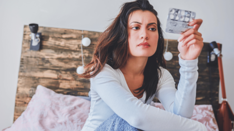 Woman looking at weight loss pills