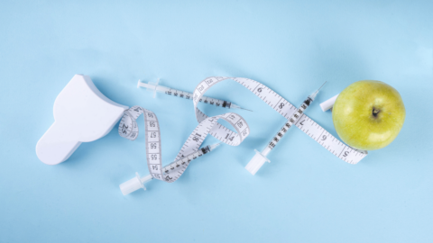 Image of a tape measure wrapped around syringes and an apple