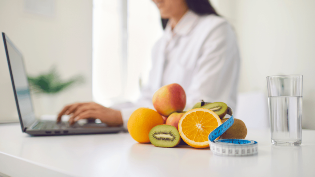 A doctor working on a laptop with fresh fruits