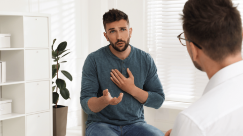 Man discussing buprenorphine-naloxone treatment for opioid addiction with doctor during consultation