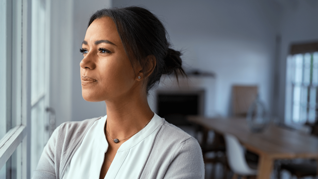 Woman looking out a window wondering if Ozempic causes depression