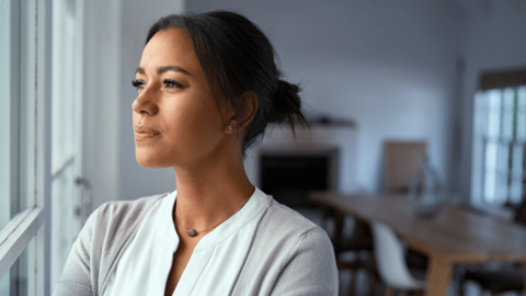 Woman looking out a window wondering if Ozempic causes depression