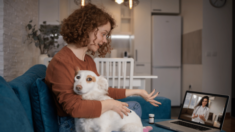 Woman with dog using QuickMD telehealth urgent care services