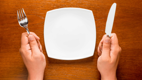 Person sitting in front of an empty plate representing semaglutide's appetite suppressing qualities