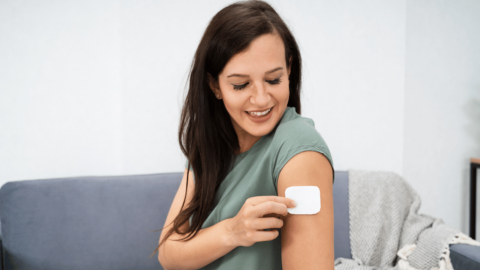 Woman applying what looks like a buprenorphine patch on arm