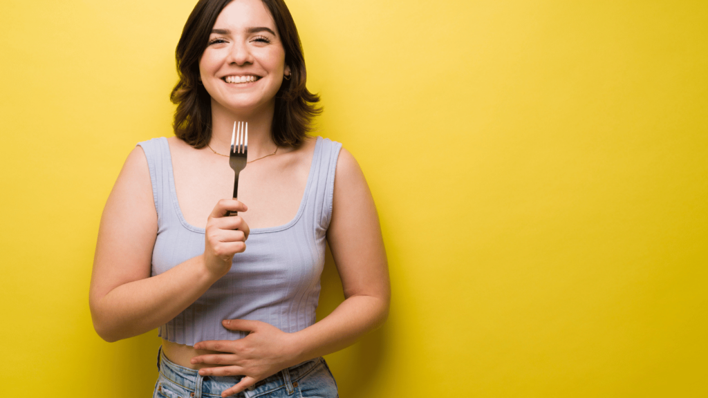 Woman on yellow background feeling full from Ozempic