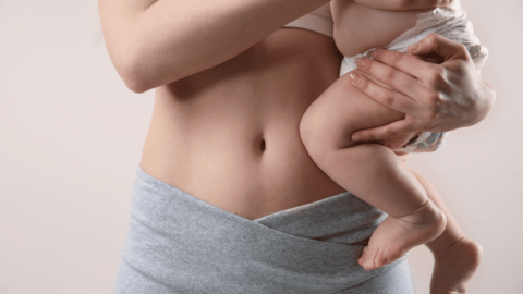 Closeup of a woman holding a baby after losing postpartum weight after C-section