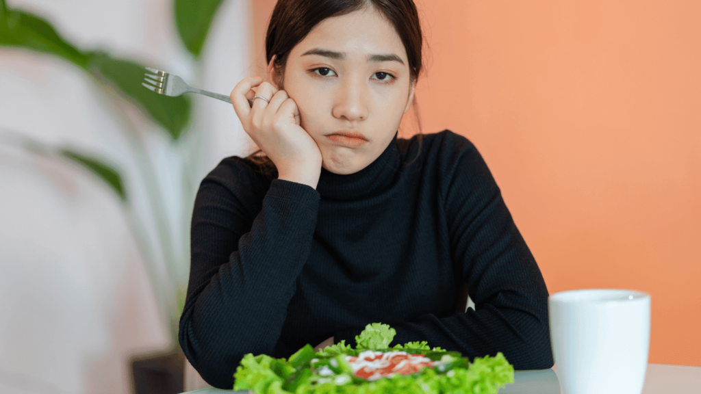 Upset woman eating a salad as part of a fad diet