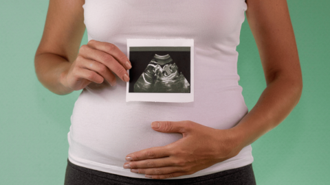 Woman holding a photo of an ultrasound during first trimester