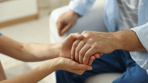 Close-up of hands offering support, symbolizing recovery from the long-term effects of opioid use on the brain and body