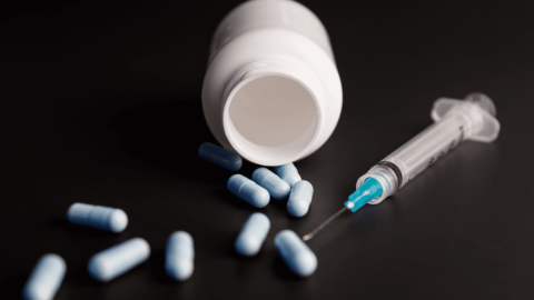 Pill bottle and syringe representing fentanyl