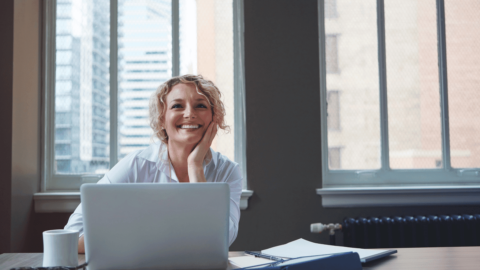 Happy woman at desk after successful Suboxone treatment