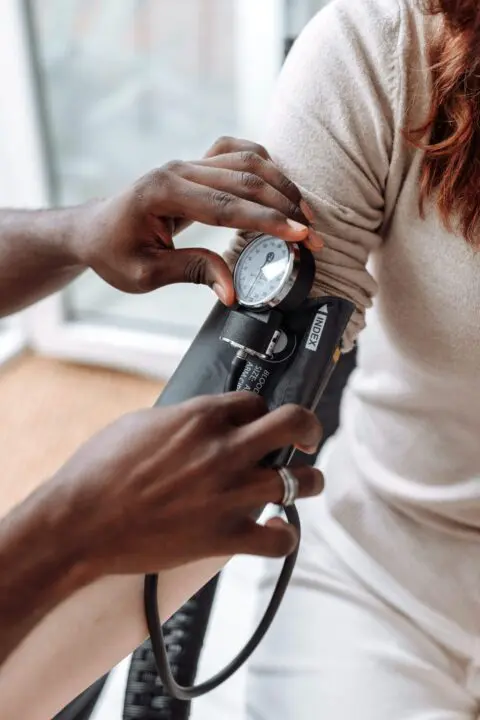 A doctor helping a patient measure blood pressure