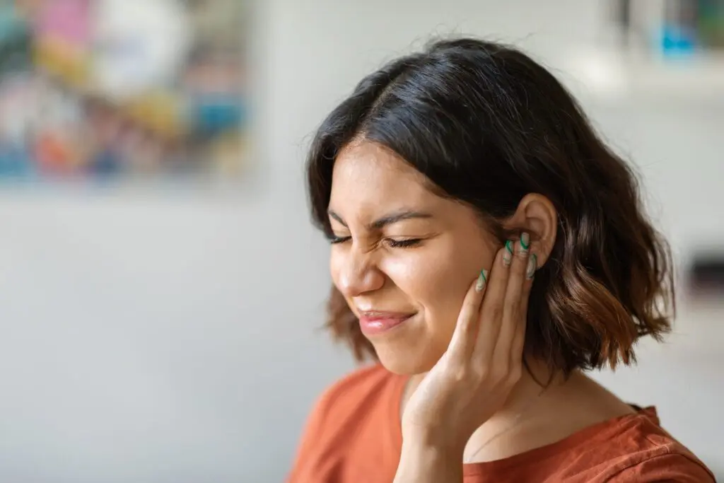 woman experiencing ear pain|An infant with middle ear infections