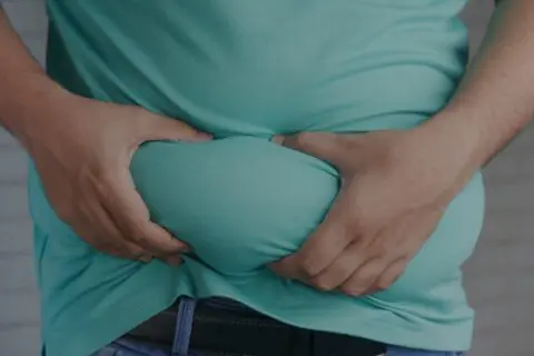 overweight man holding fat in stomach