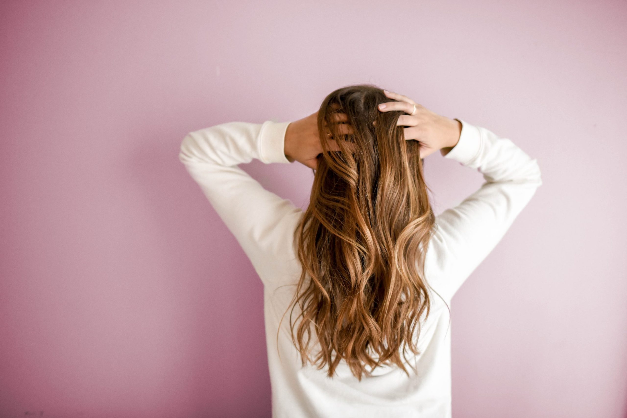 Woman touching her hair, which may be turning gray